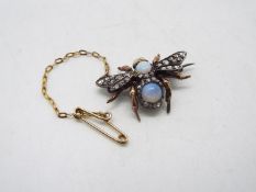 A diamond and opal set brooch in the form of a winged insect with cabochon opal to the torso and