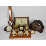 A collection of various clocks, barometer, weather station.