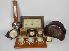 A collection of various clocks, barometer, weather station.