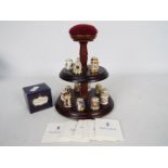 A thimble stand with fifteen Royal Crown Derby thimbles from the Historical Thimble Collection