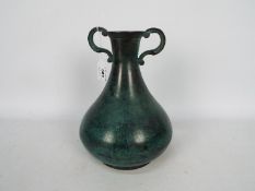 A decorative cast metal, twin handled vase, approximately 26 cm (h).