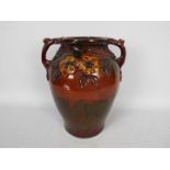 A large Longpark Pottery, Torquay twin handled vase with applied relief moulded floral decoration,