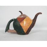 YASAHURU TAJIMA-SIMPSON (Taja) - A red earthenware teapot of stylised fruit form, part glazed,