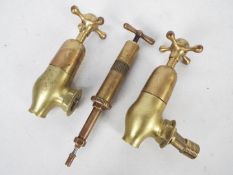 A vintage Enots brass Autoram grease gun, pattern No 3177 and a vintage set of brass taps.