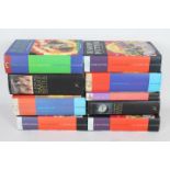 A collection of hardback Harry Potter books, including first editions.