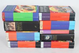 A collection of hardback Harry Potter books, including first editions.