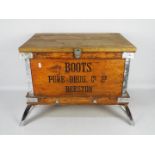 A vintage Boots Pure Drug Company wooden shipping crate, later raised on four chrome supports,