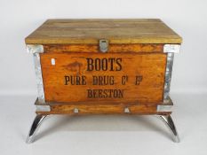 A vintage Boots Pure Drug Company wooden shipping crate, later raised on four chrome supports,