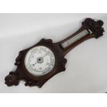 An oak cased banjo barometer with carved decoration.