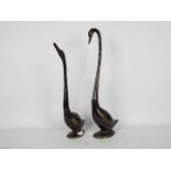 Two bronze stylised swans, largest approximately 56 cm (h).