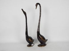 Two bronze stylised swans, largest approximately 56 cm (h).