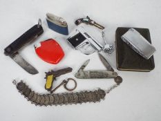 A box of mixed collectables to include cigarette lighters, flintlock pistol form brooch,