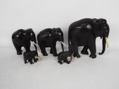 A graduated set of ebonised elephants, largest approximately 20.5 cm (h).