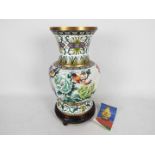A large Chinese cloisonne vase decorated with perching exotic birds amongst flowers with wooden