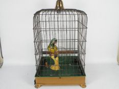 An antique birdcage with removable tray and faux parrot,