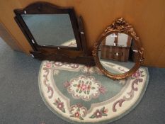 An oval framed wall mirror, one further mirror and a demi lune rug.