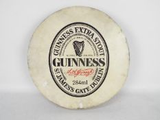 A Guinness advertising bodhran, approximately 46 cm (d).