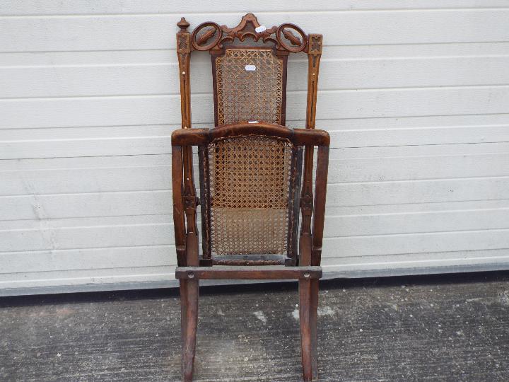 A folding chair with carved decoration, cane seat and backrest. - Image 2 of 2