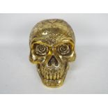 A gold coloured model of a skull,