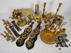 A collection of ornamental brassware to include model cannon, candlesticks,