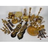 A collection of ornamental brassware to include model cannon, candlesticks,
