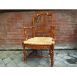 A rush seated light wood armchair