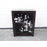 A twin door, black lacquer cabinet decorated with perching birds,