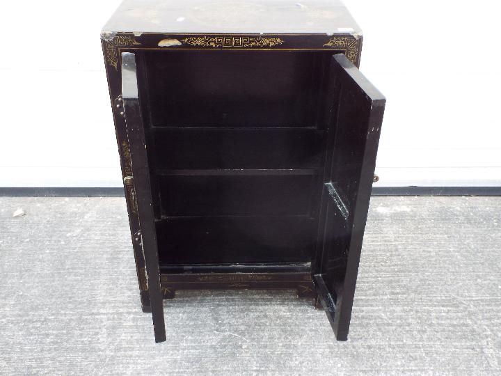 A twin door black lacquered cabinet decorated with perching birds, - Image 7 of 7