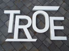 Decorative wall art - a group of metal letters painted white,