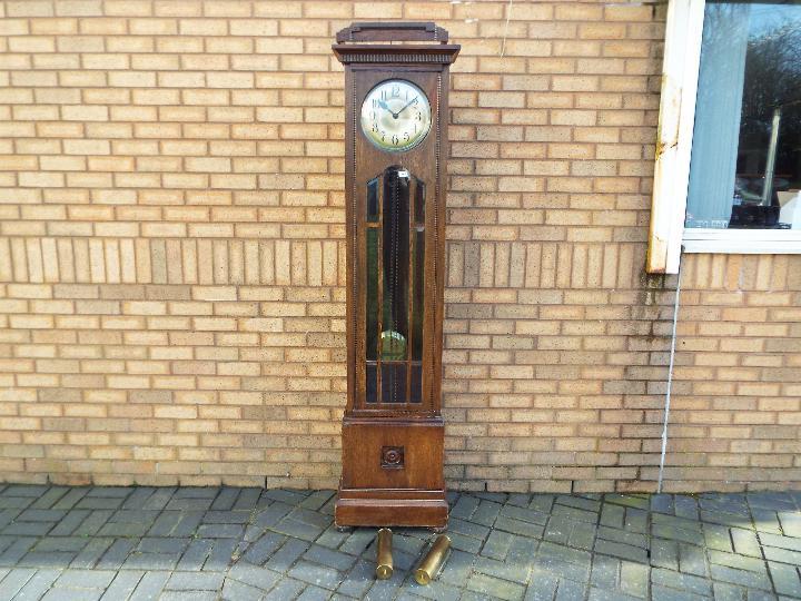 An early 20th century oak cased longcase clock, hour and half past gong striking movement,