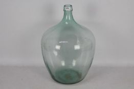 A large, green tinted glass carboy, appr