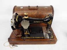 A vintage Singer sewing machine in oak case.