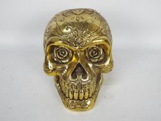 A gold coloured model of a skull,