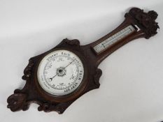 An oak cased banjo barometer with carved