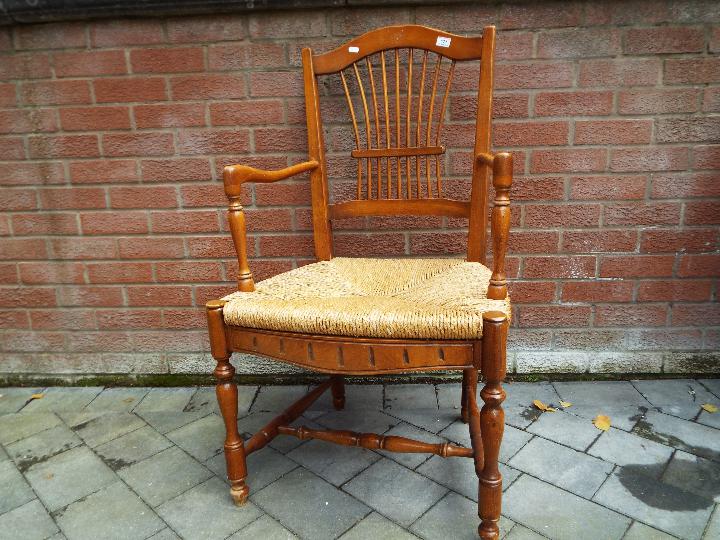 A rush seated light wood armchair