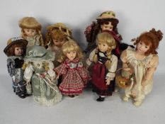 A collection of porcelain dressed dolls.
