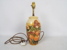 Moorcroft Pottery- a large table lamp tubelined and hand painted with finches and fruits,