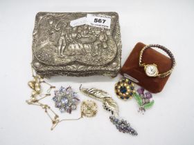 A trinket box containing a collection of brooches,