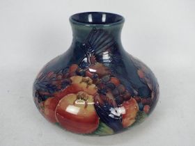Moorcroft Pottery- a large squat baluster vase tubelined and hand painted in the pomegranate