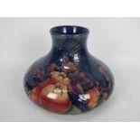 Moorcroft Pottery- a large squat baluster vase tubelined and hand painted in the pomegranate