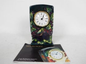 Moorcroft Pottery- a clock, tube lined and hand painted with finch and berries decoration,