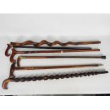 A collection of antique and later walking sticks including carved examples,