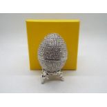 A crystal encrusted egg form trinket box with white enamel interior,