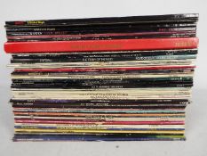 A collection of 12" vinyl records to include Queen, John Lennon, The Animals, The Who, David Bowie,