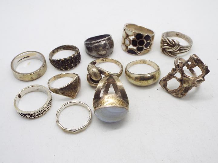 A collection of silver and white metal rings, various sizes.