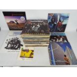 A collection of 12" vinyl records to include Black Sabbath, Pink Floyd, Madness, ELO,