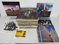 A collection of 12" vinyl records to include Black Sabbath, Pink Floyd, Madness, ELO,