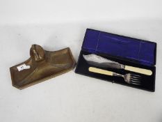 A WMF secessionist brass ink stand with central glass lined well and a cased fish server set.