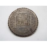 A 1792 8 Reales, Mexico mint, in white metal ropework mount and applied brooch pin.