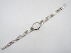 A lady's 9ct white gold wrist watch and bracelet, the white dial with diamond set quarters,
